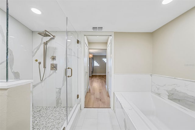 bathroom featuring a marble finish shower, visible vents, tile patterned floors, and a bath