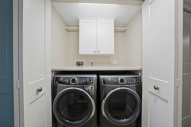 laundry area with washing machine and clothes dryer and cabinet space