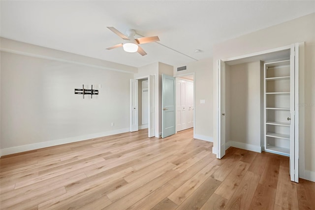 unfurnished bedroom with visible vents, multiple closets, a ceiling fan, light wood-style floors, and baseboards