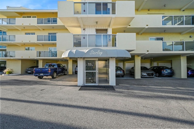 view of exterior entry with covered parking and stucco siding