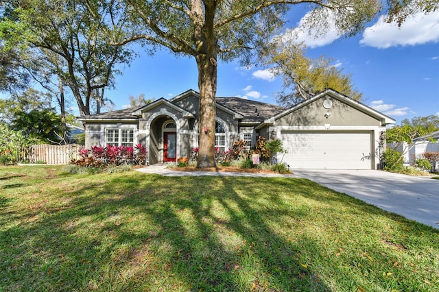 ranch-style home with concrete driveway, a front lawn, an attached garage, and fence