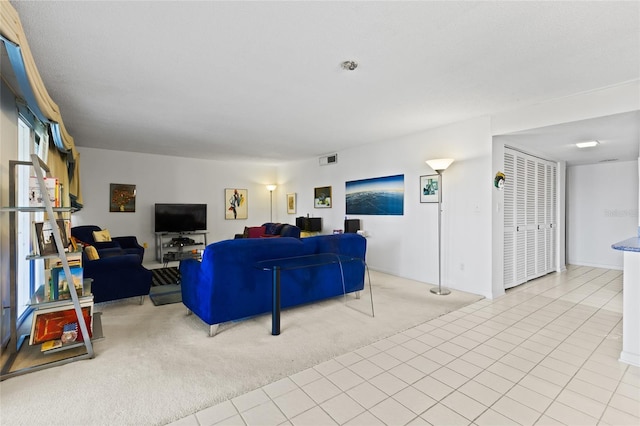 tiled living area with carpet floors and visible vents