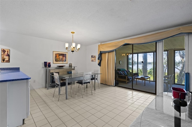 dining room with a textured ceiling, baseboards, a notable chandelier, and light tile patterned flooring