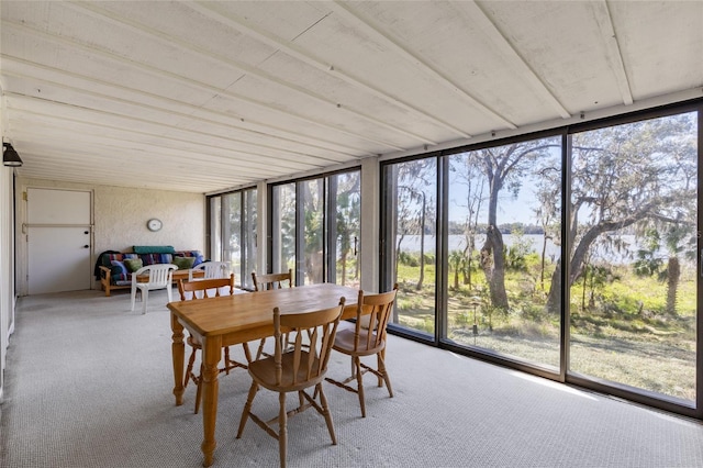 sunroom / solarium featuring a water view