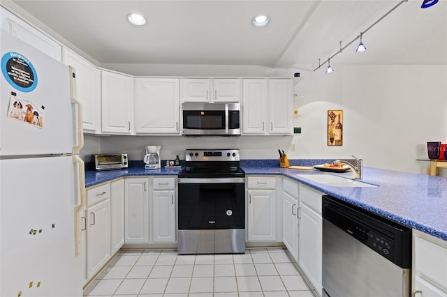 kitchen featuring appliances with stainless steel finishes, white cabinetry, a sink, and light tile patterned floors