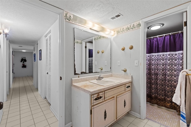 full bathroom with visible vents, a shower with shower curtain, tile patterned flooring, a textured ceiling, and vanity