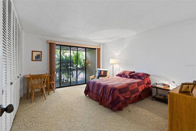 carpeted bedroom featuring a textured ceiling and access to exterior