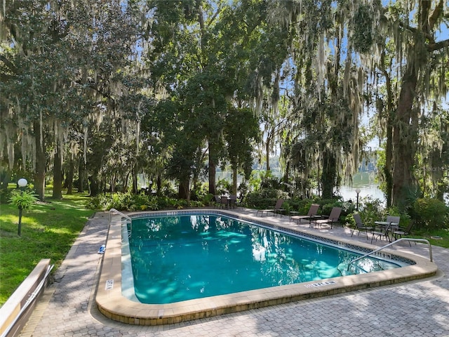 community pool featuring a patio and a lawn