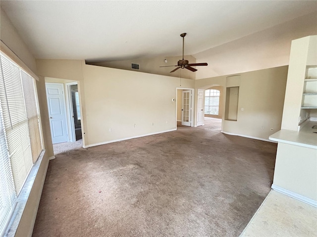 spare room featuring carpet floors, visible vents, vaulted ceiling, and a ceiling fan