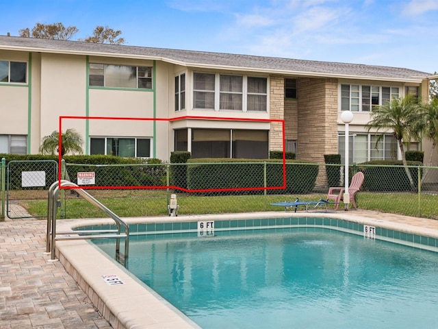 pool with fence and a lawn