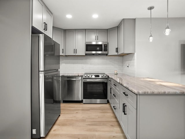 kitchen with stainless steel appliances, light wood-style flooring, and gray cabinetry