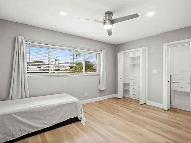 bedroom with multiple closets, recessed lighting, baseboards, and light wood finished floors