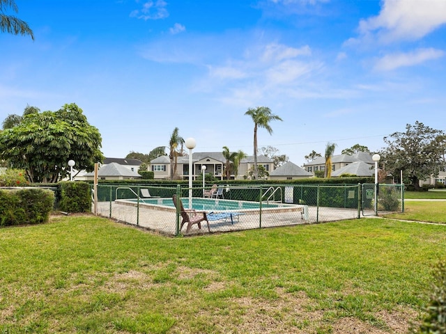 pool with a lawn, fence, and a gate