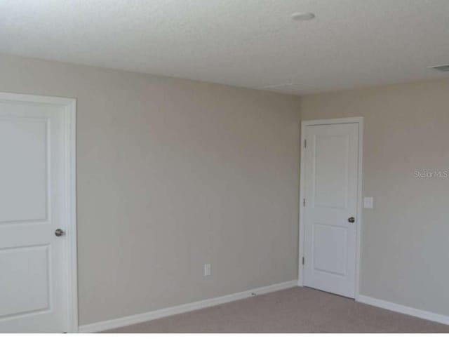 empty room with visible vents, baseboards, and light colored carpet