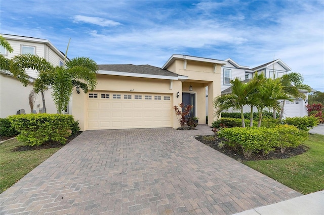 view of front of home with a garage, decorative driveway, and stucco siding