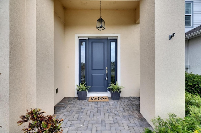 view of exterior entry featuring stucco siding