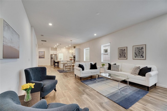 living area featuring light wood-type flooring and recessed lighting