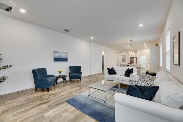 living area with light wood finished floors, visible vents, and recessed lighting