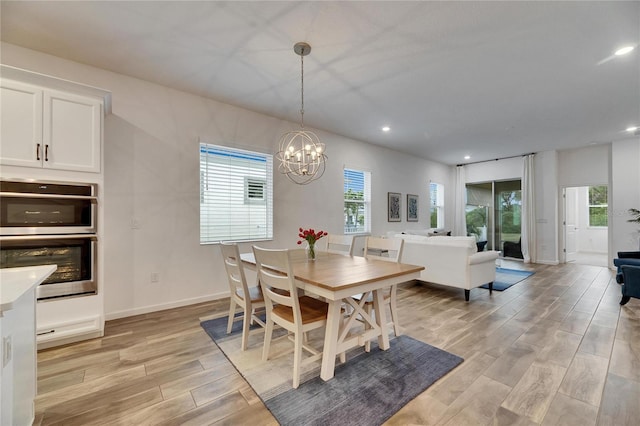 dining room featuring recessed lighting, a healthy amount of sunlight, light wood finished floors, and an inviting chandelier