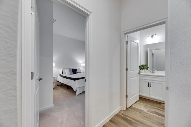 bathroom featuring baseboards, wood finished floors, and vanity