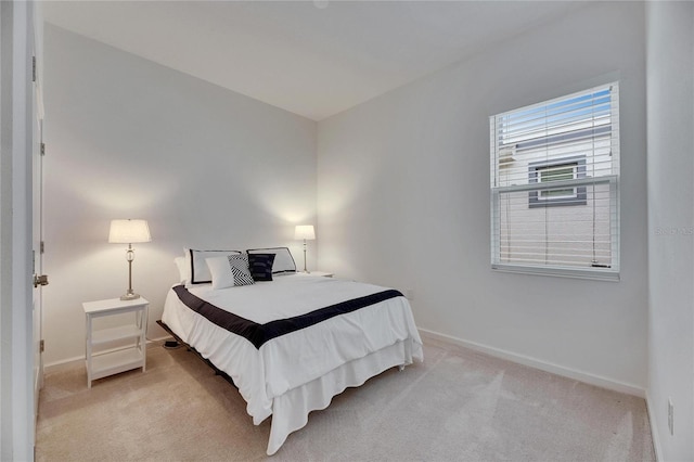 bedroom with light carpet and baseboards