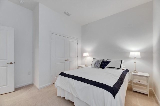 carpeted bedroom featuring a closet, visible vents, and baseboards