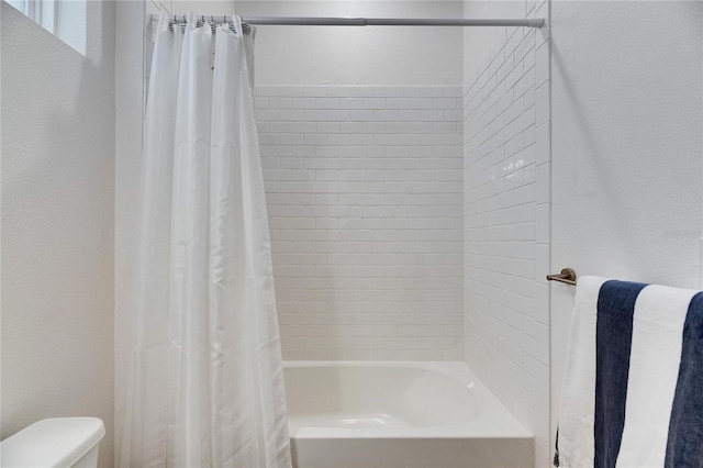 bathroom featuring toilet and shower / bath combo