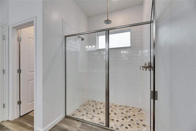 full bath featuring a stall shower and wood finished floors