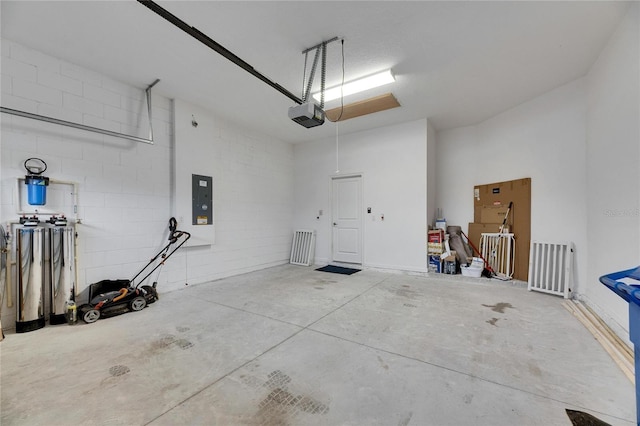 garage featuring a garage door opener and concrete block wall