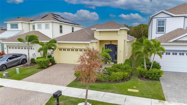 view of front of house with a garage, a shingled roof, decorative driveway, and stucco siding