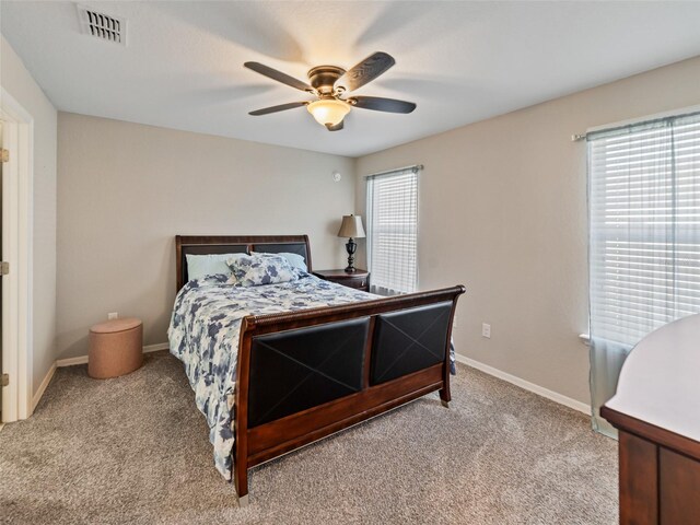 bedroom featuring baseboards, visible vents, a ceiling fan, and light colored carpet