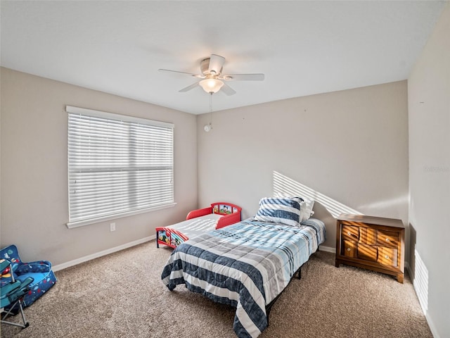 carpeted bedroom with ceiling fan and baseboards