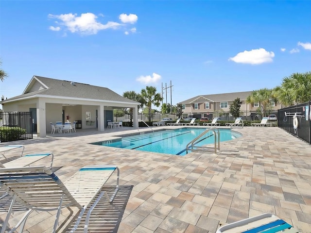 community pool featuring a patio area and fence