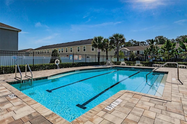 pool with a patio area, a residential view, and fence