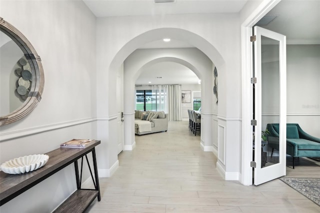 13176 Twin Bridges Dr, Riverview, FL 33579 - corridor featuring light wood-style flooring, arched walkways, and baseboards