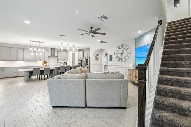 13176 Twin Bridges Dr, Riverview, FL 33579 - living area featuring stairway, recessed lighting, a ceiling fan, wainscoting, and arched walkways