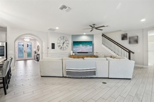 13176 Twin Bridges Dr, Riverview, FL 33579 - living area featuring arched walkways, ceiling fan, recessed lighting, french doors, and light wood-style flooring