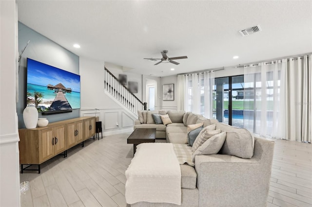 13176 Twin Bridges Dr, Riverview, FL 33579 - living room with a ceiling fan, a decorative wall, stairway, light wood finished floors, and recessed lighting