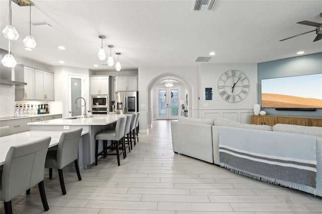 13176 Twin Bridges Dr, Riverview, FL 33579 - living room with arched walkways, recessed lighting, light wood finished floors, and a ceiling fan