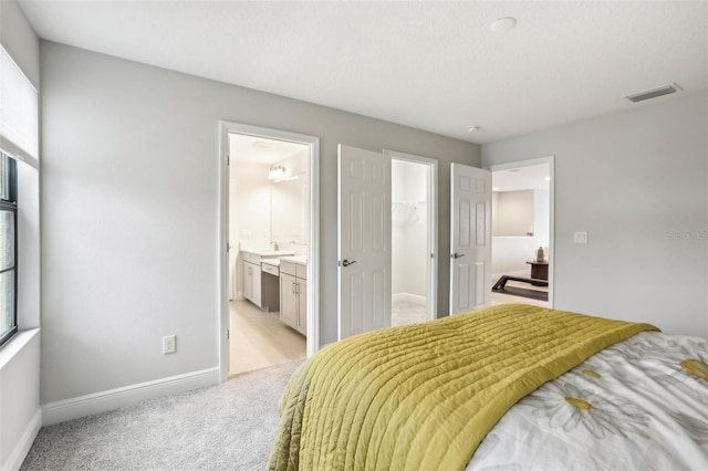 13176 Twin Bridges Dr, Riverview, FL 33579 - bedroom with light carpet, baseboards, a spacious closet, ensuite bathroom, and a closet