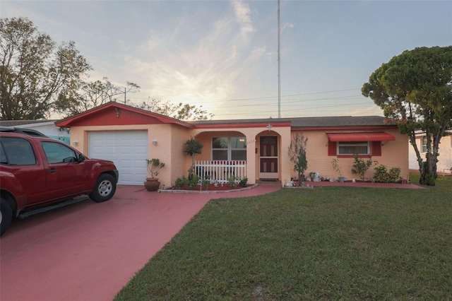 ranch-style home with an attached garage, a porch, concrete driveway, and a front yard