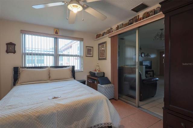 bedroom featuring a ceiling fan, a closet, visible vents, and light tile patterned floors