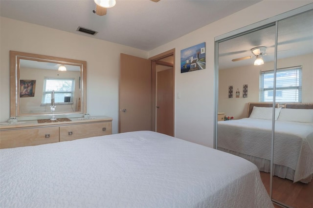 bedroom featuring ceiling fan, multiple windows, a closet, and visible vents