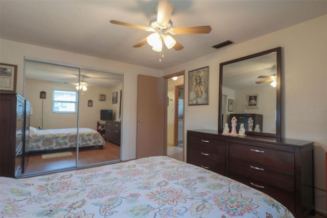 bedroom featuring ceiling fan, visible vents, and a closet