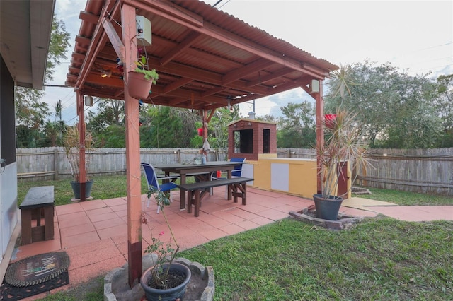 view of patio / terrace featuring outdoor dining space, a fenced backyard, and an outdoor structure