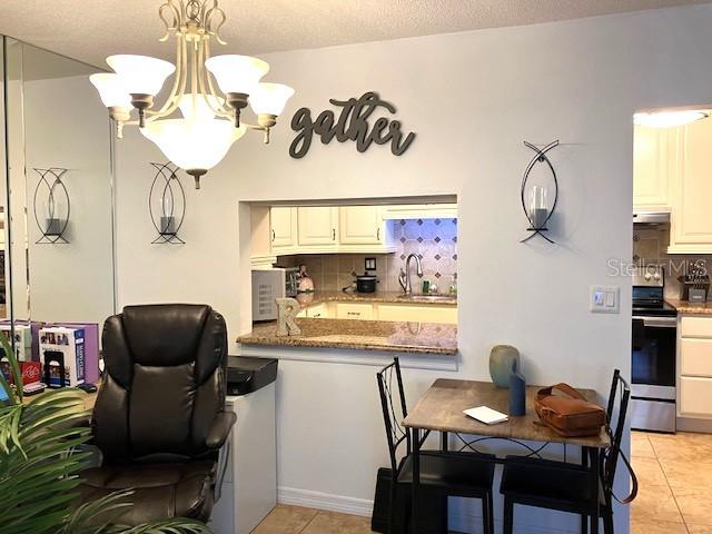 dining area featuring light tile patterned flooring and an inviting chandelier