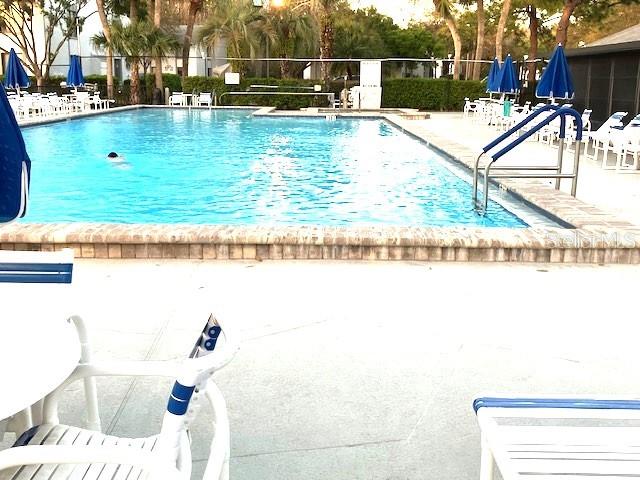 community pool featuring a patio and fence