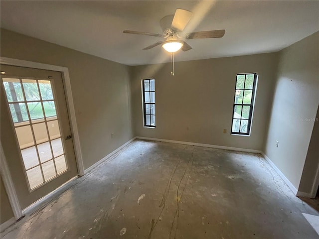 unfurnished room featuring ceiling fan and baseboards