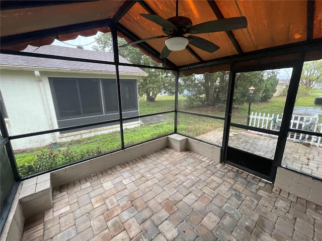 unfurnished sunroom featuring a ceiling fan and lofted ceiling