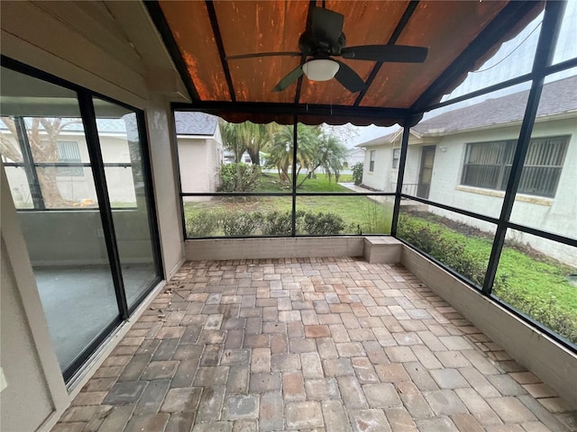 unfurnished sunroom with vaulted ceiling and a ceiling fan